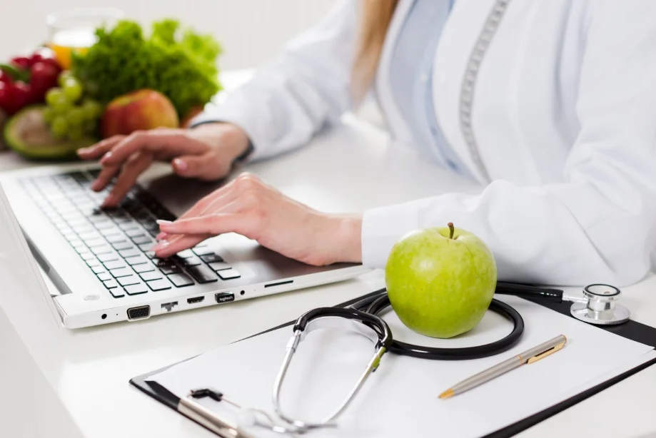 Nutricionista embarazo en un ordenador con una manzana