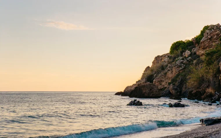 Costa rocosa al atardecer, ejemplo de ecosistema marino evaluado por consultoras ambientales en estudios de impacto ecológico.