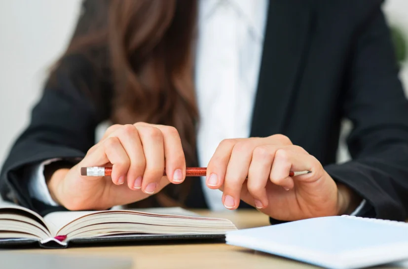 Abogada en escritorio con libro abierto y bolígrafo en las manos, concepto de mejores abogados penalistas España.