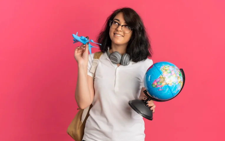Joven con globo terráqueo y avión de juguete representando las mejores empresas para estudiar en el extranjero