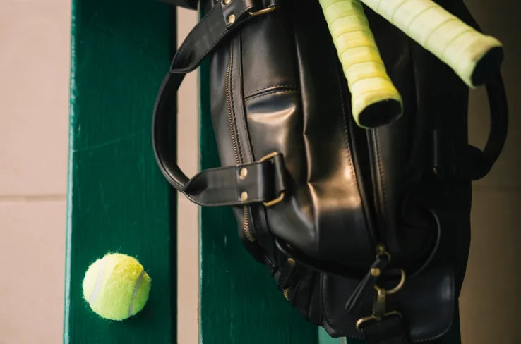 Bolsa deportiva elegante junto a pelota de tenis para accesorios deportivos de raqueta